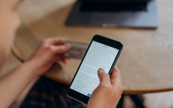 Close-up of a person holding a smartphone and credit card. Ideal for online shopping concepts.