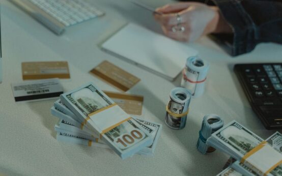 Close-up of dollar bills and credit cards on a desk, symbolizing financial transactions.